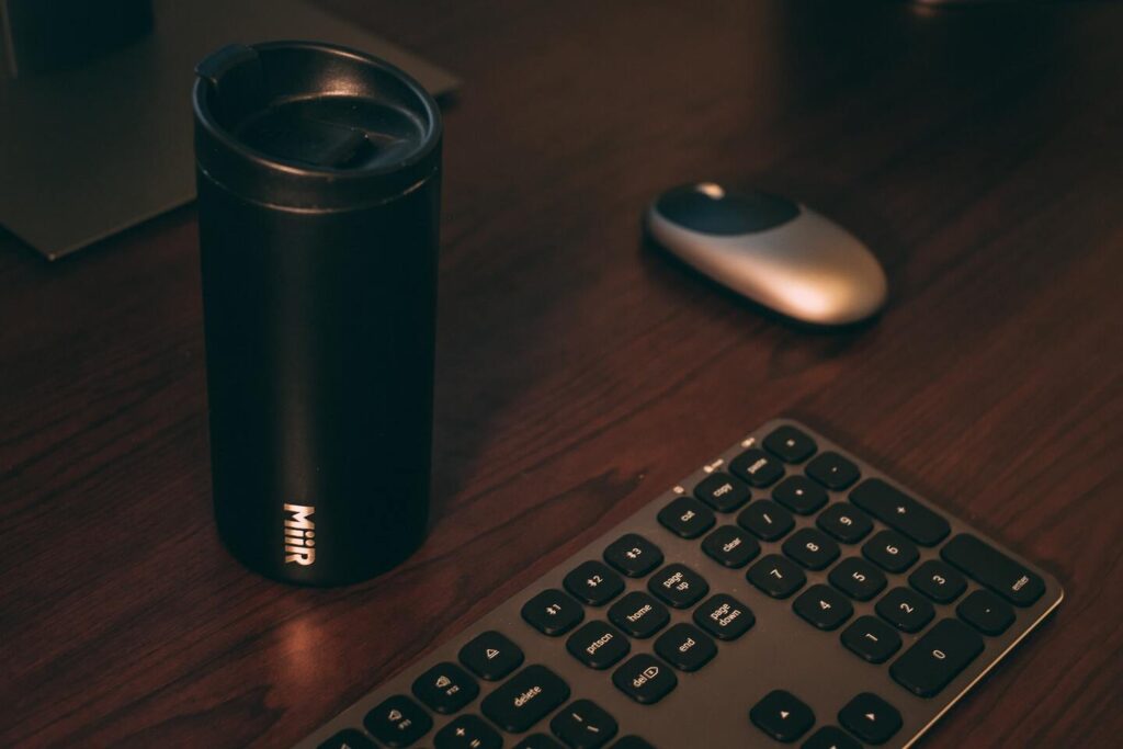 A Steel tumbler mouse and keyboard lying on the table representing the query : Sublimation on stainless Steel . Can you sublimate on stainless steel or sublimating on stainless steel.