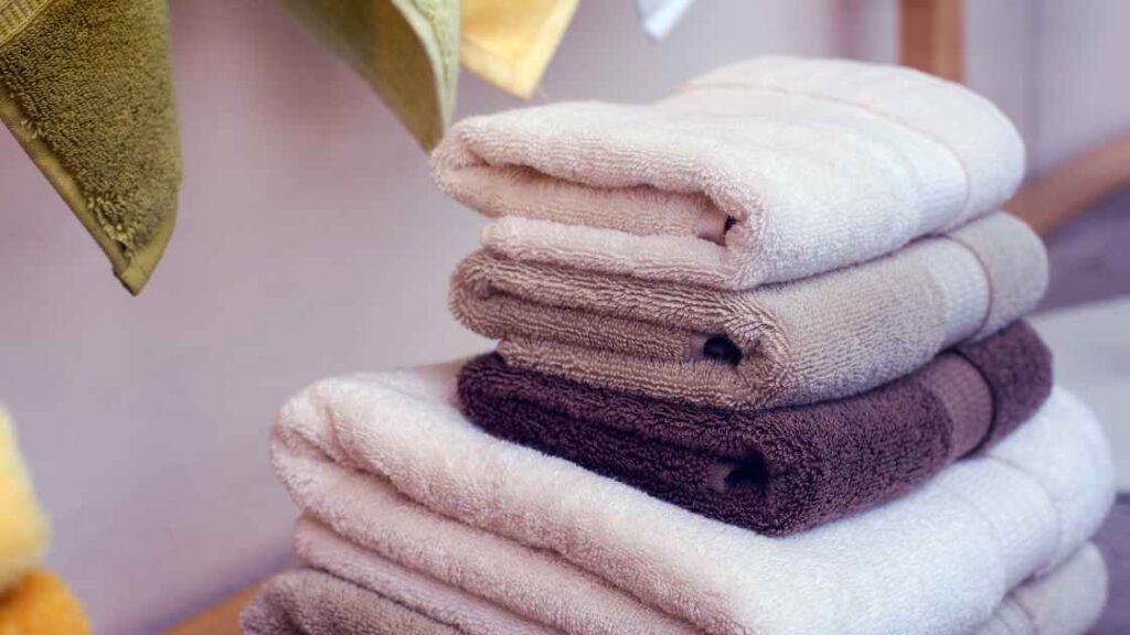 Some towels alligned up each othe vertically representing the query: Can you put wet clothes in the dryer? Or Can you put soaking wet clothes in the dryer? Or What happens when you put wet clothes in the dryer? Or Can i put wet clothes in the dryer? Or Can i put soaked clothes in the dryer?