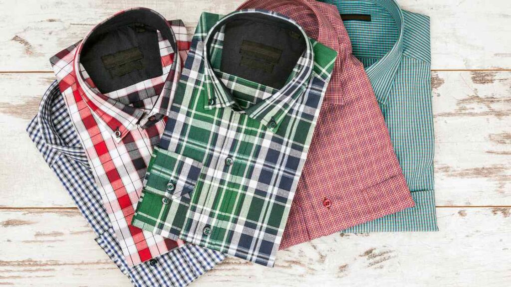 Some checkered style dress shirts folded representing the queries: How much does a shirt weigh ? Or How much does a t shirt weigh ? Or How much does a t-shirt weigh ? Or How much does a shirt weigh in lbs ? Or How much does a shirt weigh to ship ? Or How much does a tshirt weigh ? How much does shirt weigh ? Or How much do shirts weigh ?