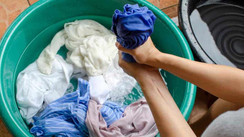 A person hand washing clothes representing the query: Can you wash multiple tie dye shirts together ? Or Can i wash multiple tie dye shirts together ?
