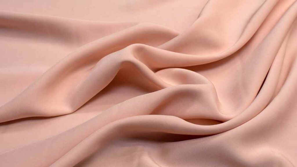 A light pink colored rayon fabric representing the queries: Can you dye rayon ? Or Can you tie dye rayon ? Or Can you tie dye rayon spandex ? Or Can rayon be dyed ? Or Is dyeing rayon possible ? Or Is dying rayon possible ? Or How to dye rayon ?