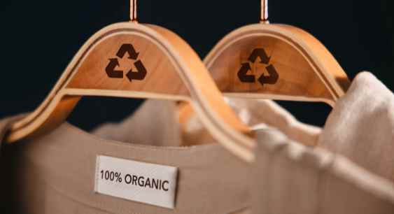 Two cotton shirts with one 100 percent organic cotton shirt hanging on a hanger with the "Recycle" tag representing the queries: Does Organic cotton shrink ? Or Will organic cotton shrink ? Or How to Wash Organic Cotton ? Does Cold Water shrink Cotton ?