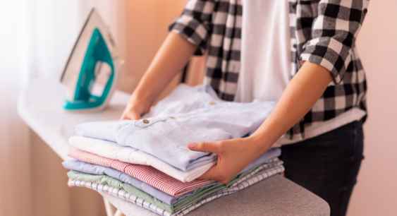 A person folding and preparing the washed shirts to store representing the queries: What is a triblend shirt ? Or What is a TriBlend T shirt ? Or What are tri blend t shirts? Or What is a Tri blend t shirt ? Or What is tri blend shirt?