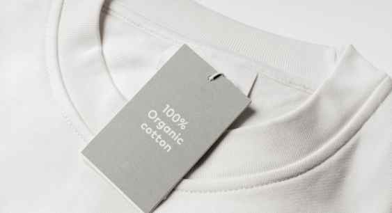 A grey colored organic cotton shirt with 100 percent organic cotton tag on it representing the queries: Does Organic cotton shrink ? Or Will organic cotton shrink ? Or How to Wash Organic Cotton ? Does Cold Water shrink Cotton ?
