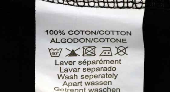 A cotton fabric tag with washing instructions on it representing the queries: Does Organic cotton shrink ? Or Will organic cotton shrink ? Or How to Wash Organic Cotton ? Does Cold Water shrink Cotton ?